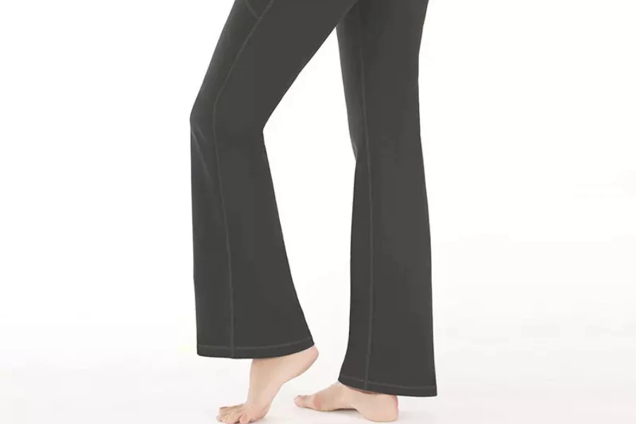 Woman wearing dark gray flare yoga pants with seams